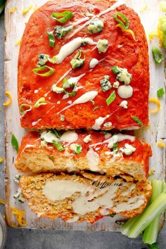 two slices of meatloaf on a cutting board with sauce, cheese and green onions