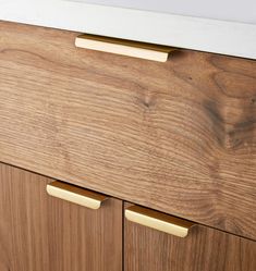 a close up of a wooden cabinet with white handles and knobs on the drawers