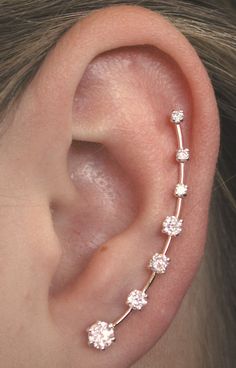 a woman's ear is shown with three small flowers on it