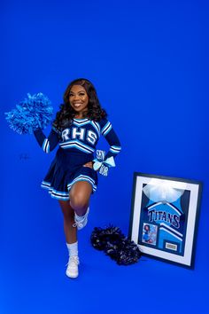 a cheerleader posing with her pom - poms in front of a blue background