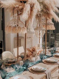 a table set with place settings and feathers on top of the tables for an elegant dinner party