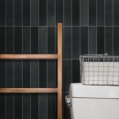 a basket sitting on top of a toilet next to a wooden chair in a bathroom