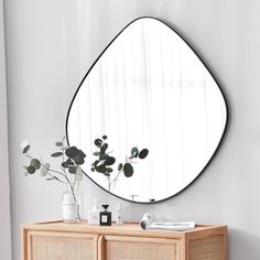 a mirror on the wall above a dresser