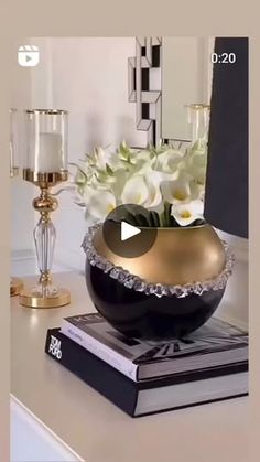 a vase with flowers in it sitting on top of a table next to a book