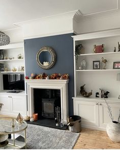 a living room filled with furniture and a fire place next to a wall mounted tv