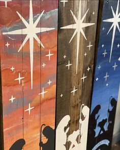 three wooden boards with nativity images painted on them