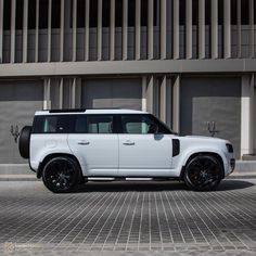 a white suv parked in front of a building