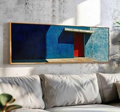 a painting hanging on the wall above a couch