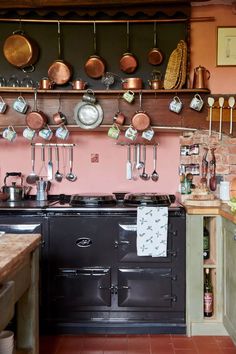 an old fashioned kitchen with pots and pans hanging on the wall