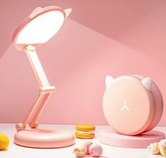 a pink desk lamp sitting on top of a table