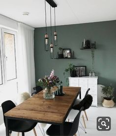 a dining room table with chairs and vases on top of it in front of a window