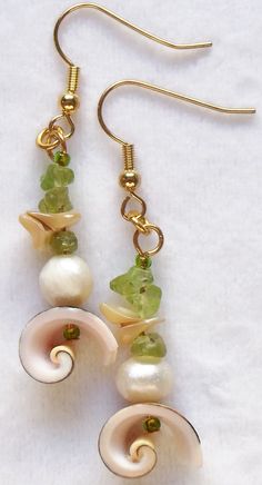 two pairs of earrings with pearls and green beads hanging from gold - tone earwires