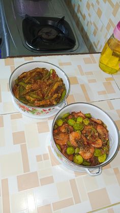 two bowls filled with food sitting on top of a counter