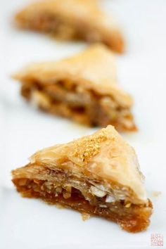 three pieces of pie sitting on top of a white table next to another piece of food