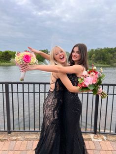 two beautiful women standing next to each other holding bouquets in their hands and posing for the camera