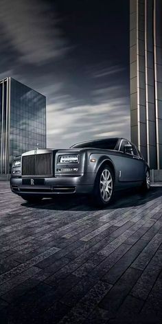 a black rolls royce parked in front of a tall building