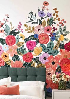 a bedroom decorated with colorful floral wallpaper