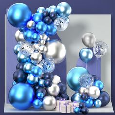 blue and silver balloons are floating in the air next to a white box with presents