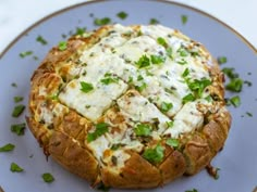 a baked bread dish with cheese and herbs on a blue plate, ready to be eaten