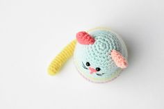 a crocheted toy with a pink bow on it's head sitting on a white surface