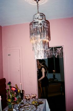 a chandelier hanging from the ceiling in a pink room