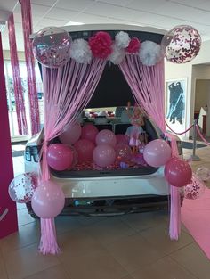 a car decorated with pink and white balloons