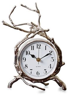 a clock that is sitting on a tree branch in front of a white background with no numbers