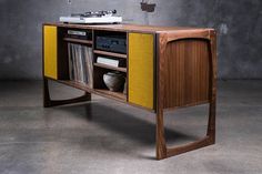 an old fashioned television stand with a yellow cabinet on it's side and a sink in the center