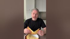 an older man is eating bread on a plate