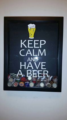 a sign that says keep calm and have a beer in front of it with lots of bottle caps