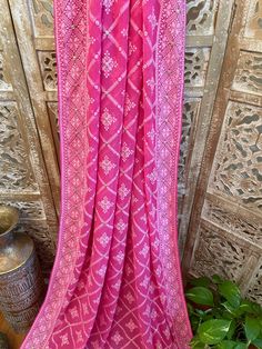 A very very pretty Chikankari saree in pure georgette in a lovely candy pink shade with all over jaal (barfi pattern) embroidery with mukaish work (embellishments). The pallu is short but features intricate designs. The entire saree has the same pattern from the very beginning of the saree except the portion you have to tuck in so that it doesn't bulge. Entire saree is framed in cord piping, best quality satin falls are attached and picot stitching is done as well. The blouse piece is separated Pink Bandhani Print Pre-draped Saree For Festivals, Festive Pink Pre-draped Saree With Motifs, Eid Pink Pre-draped Saree With Dupatta, Pink Festive Saree With Motifs, Pink Pre-draped Saree With Dupatta For Eid, Pink Pre-draped Saree With Dupatta For Festivals, Pink Cutdana Dupatta For Traditional Ceremonies, Pink Saree With Motifs In Traditional Drape, Pink Chanderi Saree With Motifs