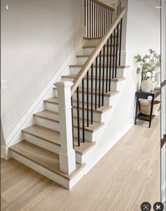 a white staircase with wooden handrails in a house