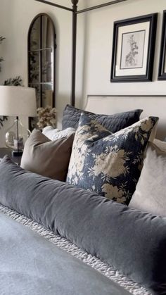 a bed with pillows and pictures on the wall above it, along with two lamps