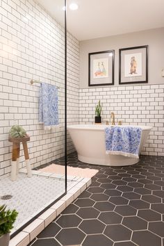 a bathroom with black and white tile flooring, two framed pictures on the wall