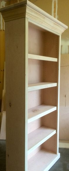 an empty bookcase in the middle of a room with unfinished walls and flooring