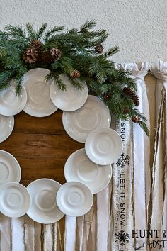 a wreath made out of plates and pine cones