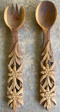 two wooden spoons with carved designs on them