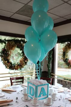 a birthday cake with balloons on top of it in the middle of a dining room