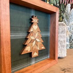 a wooden christmas tree on display in a frame