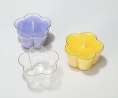 three candles sitting next to each other on a white surface with one candle in the middle