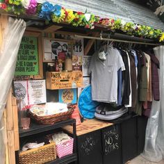 an outdoor clothing store with lots of clothes hanging on the rack and other items in baskets