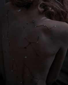 the back of a woman's body with stars on it