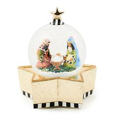 a snow globe sitting on top of a wooden stand with a nativity scene in it