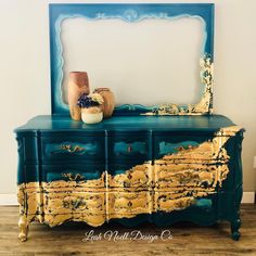 a blue and gold dresser with a mirror on top