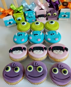 cupcakes decorated with different colored frosting and eyes are arranged on a table