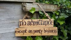 a wooden sign hanging from the side of a building that says no admittance except on party business