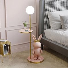 a pink bunny lamp sitting on top of a table next to a bed and nightstand