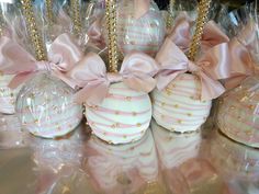 some pink and white chocolates wrapped in plastic with bows on them are lined up next to each other