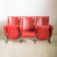 three red leather chairs sitting next to each other