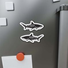 two stickers on the side of a refrigerator with magnets attached to it's sides